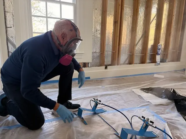A restoration technician setting drying equipment in a Lafayette home stripped to the studs